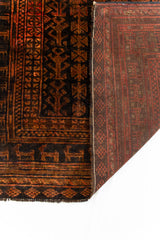Detalle del reverso de la alfombra oriental en tonos tierra, mostrando el entramado de nudos y su diseño artesanal.