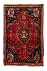 Alfombra persa de diseño geométrico con gran medallón central y fondo rojo intenso, decorada con motivos florales.