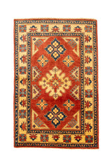 Alfombra rectangular con fondo rojo intenso y motivos geométricos en tonos beige y azul.