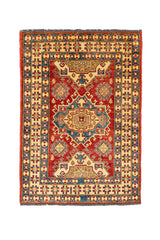 Alfombra oriental con fondo rojo intenso, medallones centrales geométricos en tonos beige, azul y dorado, y bordes con motivos cruzados sobre fondo beige.