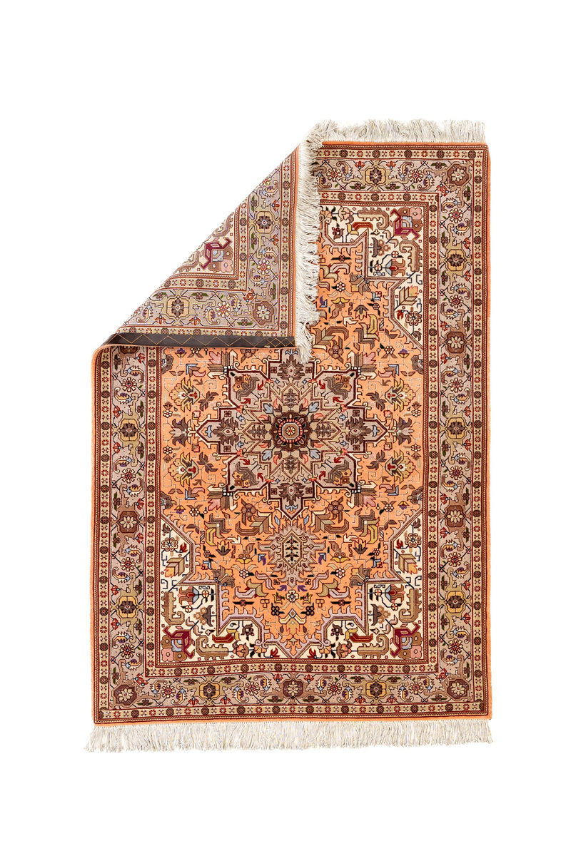 Fotografía con la esquina superior doblada, revelando el reverso de la alfombra y su nudo fino.