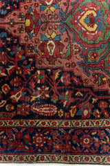 Detalle cercano del diseño de la alfombra persa, con motivos florales en tonos rojos, verdes y azules sobre fondo oscuro.