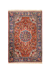 Vista completa de alfombra con fondo rojo vibrante, decoración floral simétrica y bordes azul oscuro ornamentados.