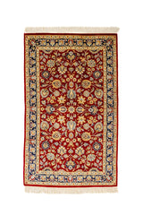 Vista superior completa de alfombra oriental con fondo rojo y patrón floral simétrico en tonos dorados, beige y azul marino.