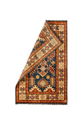 Alfombra parcialmente doblada, mostrando el reverso tejido a mano y la definición de los bordes con detalles ornamentales clásicos.