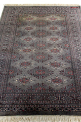 Detalle en perspectiva de la superficie de la alfombra mostrando la profundidad del diseño geométrico y el acabado textil.
