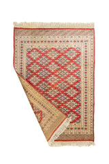 Alfombra doblada mostrando tanto el anverso como el reverso, con detalles de tejido tradicional y flecos decorativos.