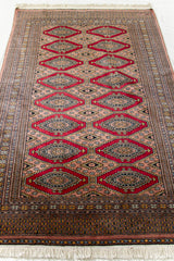 Vista en perspectiva de la alfombra extendida, destacando el patrón central en forma de rombos y el contraste de colores.