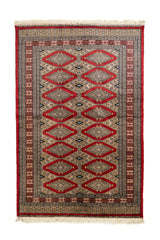 Vista superior de alfombra oriental con patrón de rombos en rojo y beige, enmarcada por múltiples franjas decorativas en tonos tierra y negro.