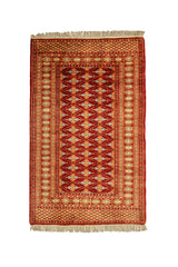 Vista superior de una alfombra oriental con fondo rojo y patrones simétricos en tonos dorado, celeste y beige.