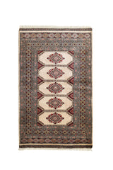 Vista completa de una alfombra oriental con fondo crema y patrones geométricos simétricos en rojo y negro.