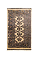 Vista frontal completa de alfombra oriental con fondo crema y motivos geométricos en azul y marrón.
