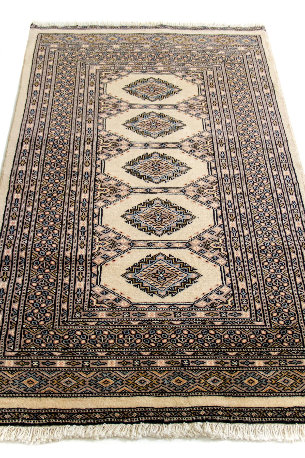 Vista en ángulo de la alfombra oriental resaltando los patrones centrales y la simetría del diseño.