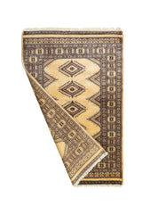 Alfombra oriental parcialmente doblada mostrando su reverso y la textura artesanal del tejido.
