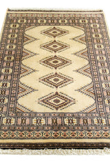 Vista en ángulo de la alfombra resaltando los patrones romboidales centrales y el marco decorativo.