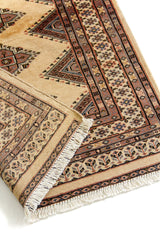 Detalle cercano del borde y la esquina de la alfombra, mostrando la calidad del tejido, flecos y motivos decorativos.