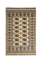 Vista completa de una alfombra oriental con fondo beige y patrones geométricos repetidos en tonos negros y marrón.