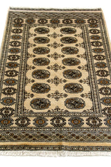 Perspectiva inclinada de la alfombra oriental, destacando la disposición simétrica de los motivos centrales y el marco decorativo.