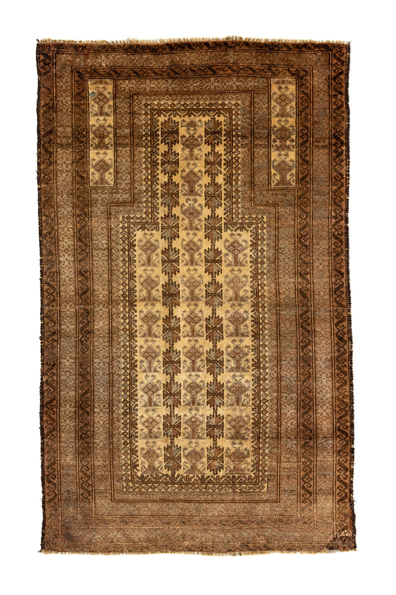 Alfombra oriental parcialmente doblada que revela el reverso, con diseño simétrico en tonos cálidos