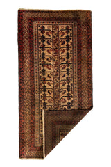 Alfombra oriental mostrada parcialmente doblada en una esquina para revelar su reverso, destacando su textura tejida artesanalmente.