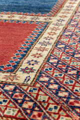 Detalle del borde lateral de la alfombra, mostrando la transición entre el panel rojo y la guarda decorativa con estrellas en tonos azul, rojo y dorado.