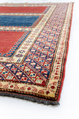 Perspectiva lateral de la alfombra destacando su grosor, las fibras tejidas a mano y la riqueza de los detalles en los motivos geométricos.