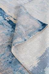 Detalle del reverso y textura de alfombra azul con diseño abstracto desgastado