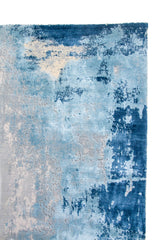 Detalle de borde de alfombra Ocean Mist en tonos celeste, azul y gris