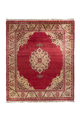 Alfombra clásica oriental en rojo con medallón central marfil y guarda floral beige, vista superior.