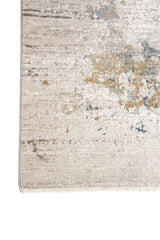 Detalle de borde y flecos de alfombra rectangular gris claro con diseño abstracto y acentos celestes