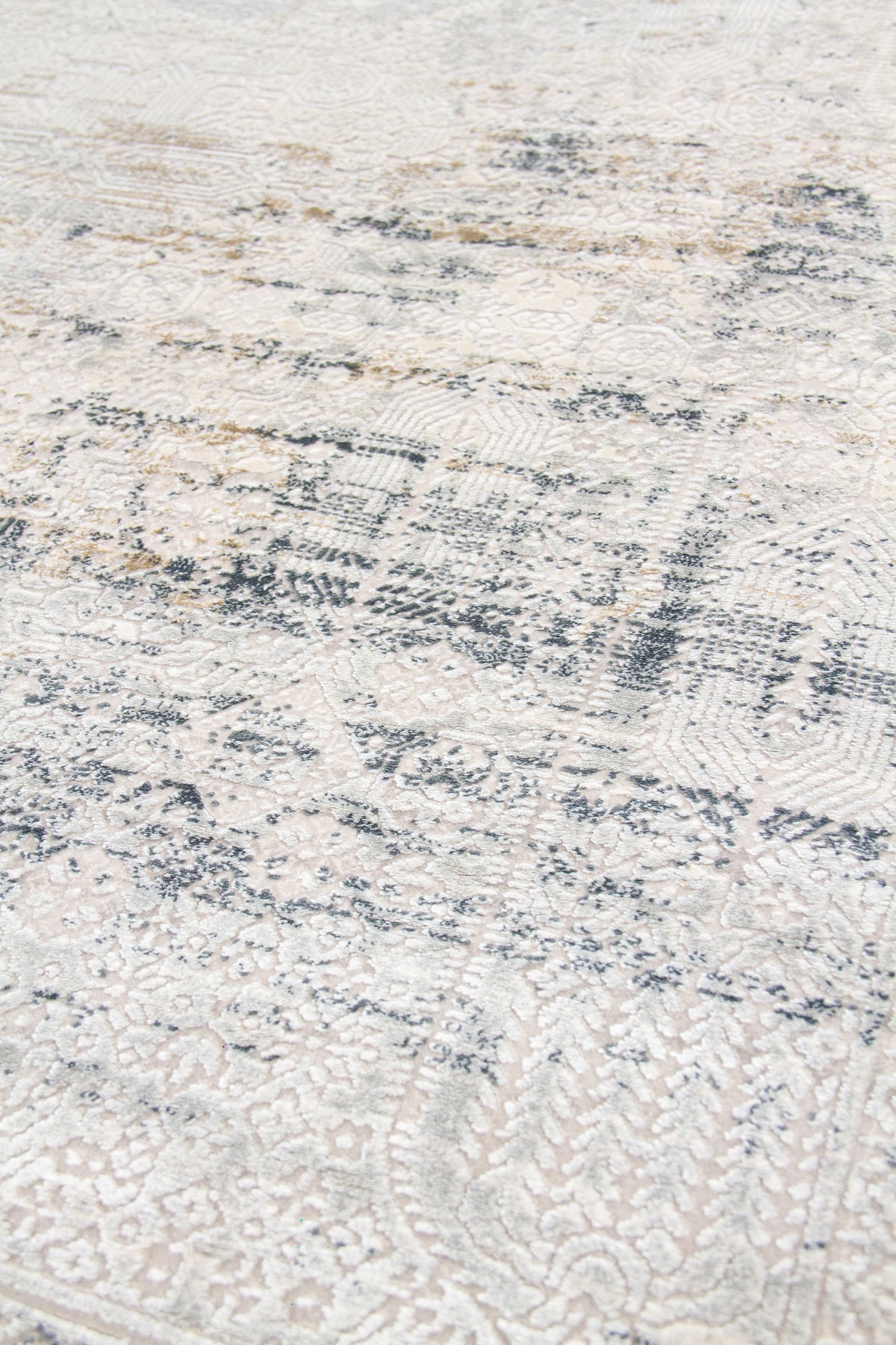 Detalle de textura de alfombra rectangular con diseño abstracto en beige claro y gris