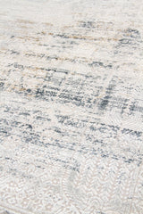 Detalle de textura de alfombra rectangular con diseño abstracto en beige claro y gris