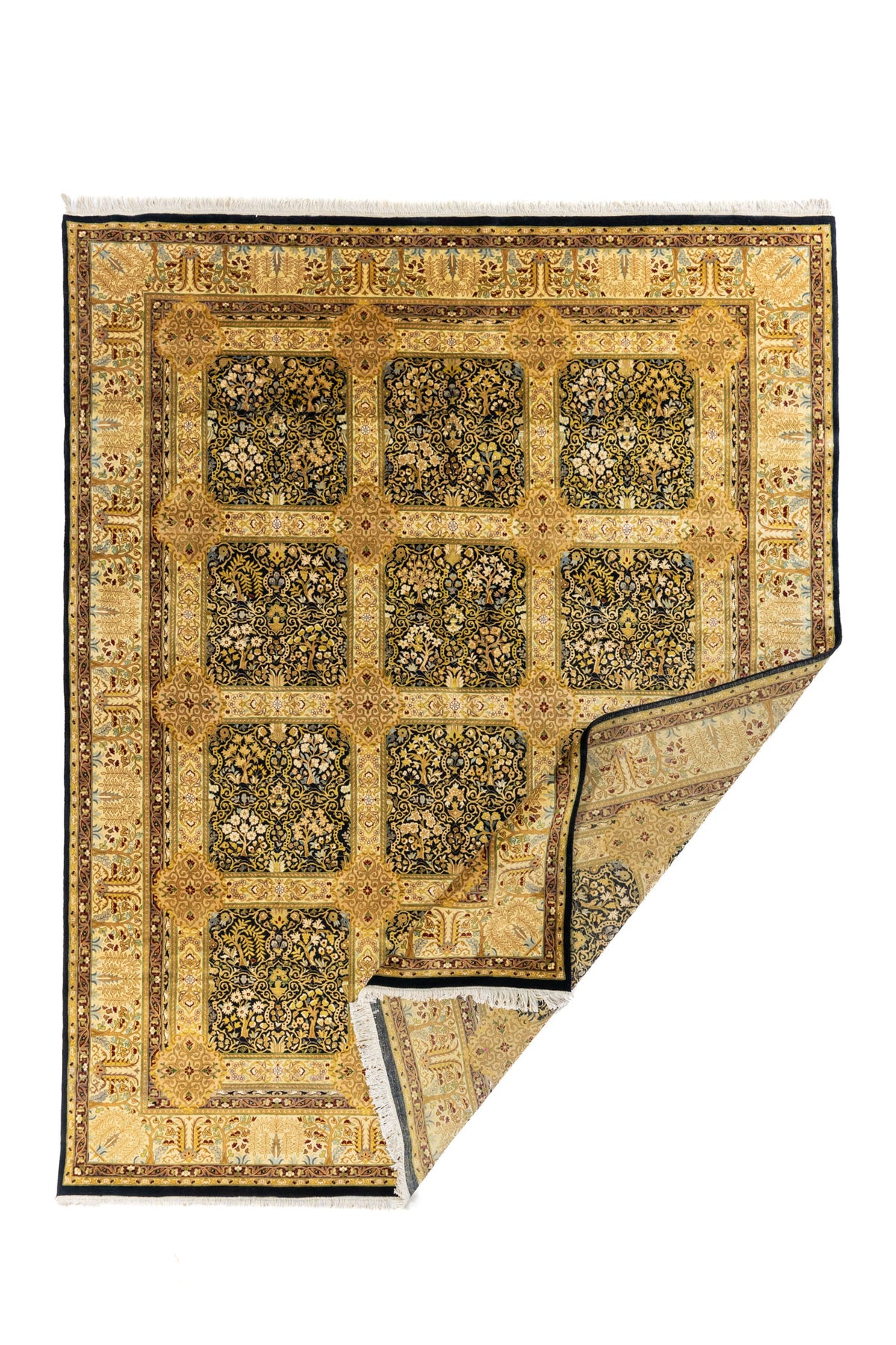 Alfombra oriental dorada con esquina doblada, mostrando el reverso y su diseño de paneles florales sobre fondo oscuro.