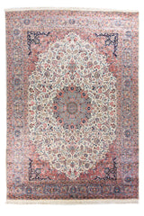 Alfombra clásica de estilo persa en tonos marfil, azul y rosado con medallón central floral y guarda ornamental detallada.