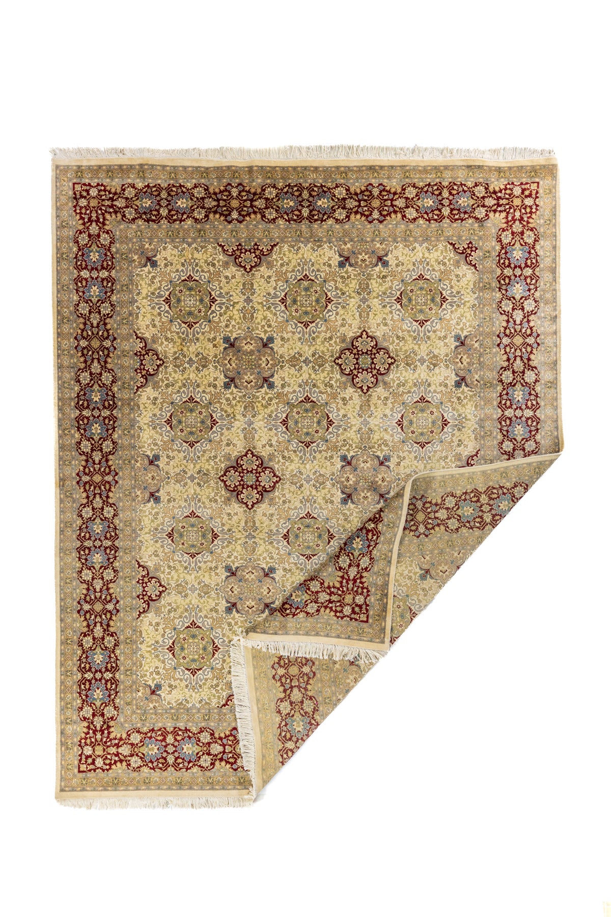 Alfombra clásica floral en color beige con borde rojo vino, mostrada con una esquina doblada para ver el reverso y el grosor.