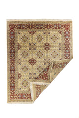 Alfombra clásica floral en color beige con borde rojo vino, mostrada con una esquina doblada para ver el reverso y el grosor.