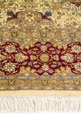 Primer plano de la guarda roja vino con flores estilizadas y flecos marfil en alfombra de estilo clásico.