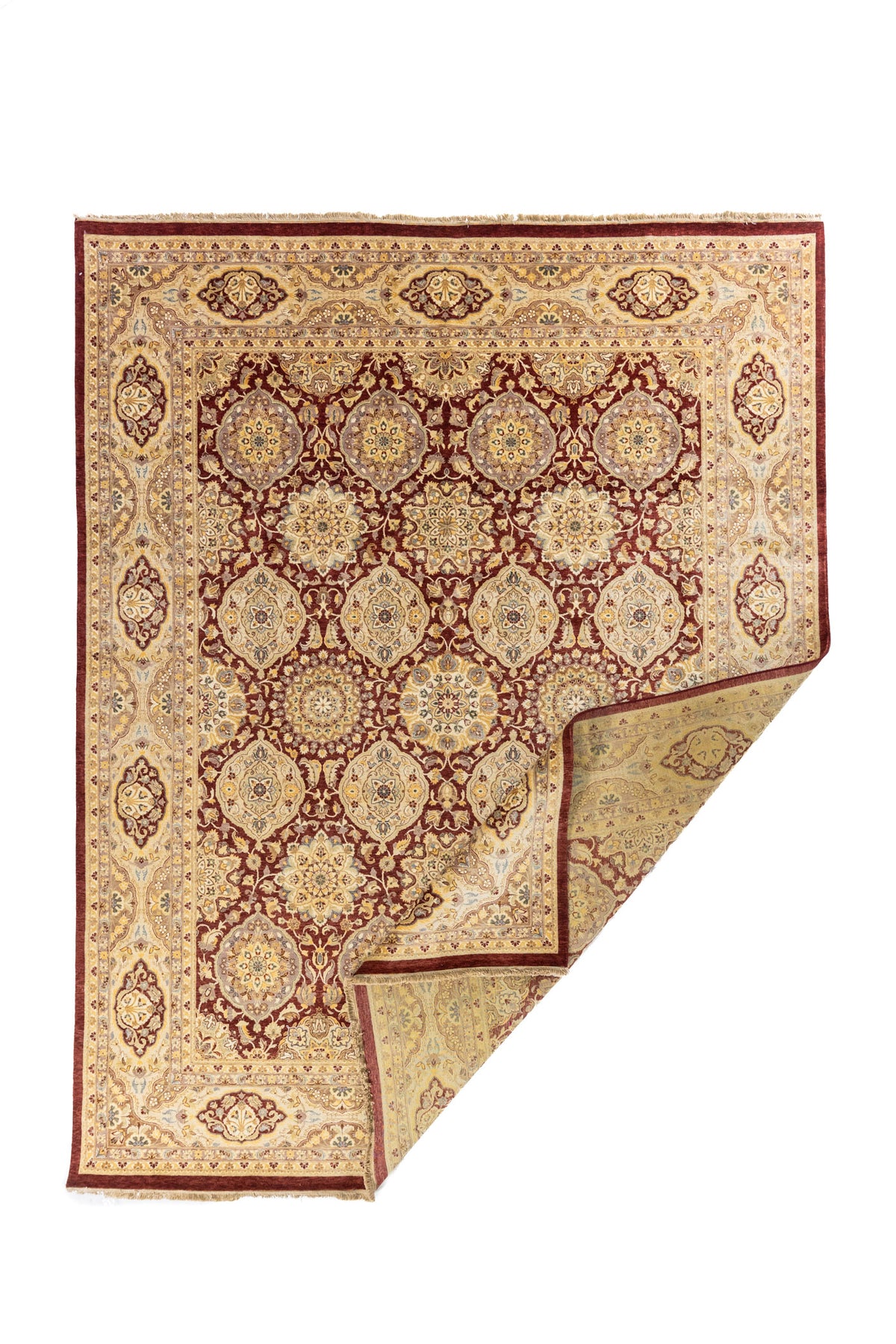 Alfombra oriental roja y beige con esquina doblada, mostrando el reverso y el detalle de tejido artesanal.