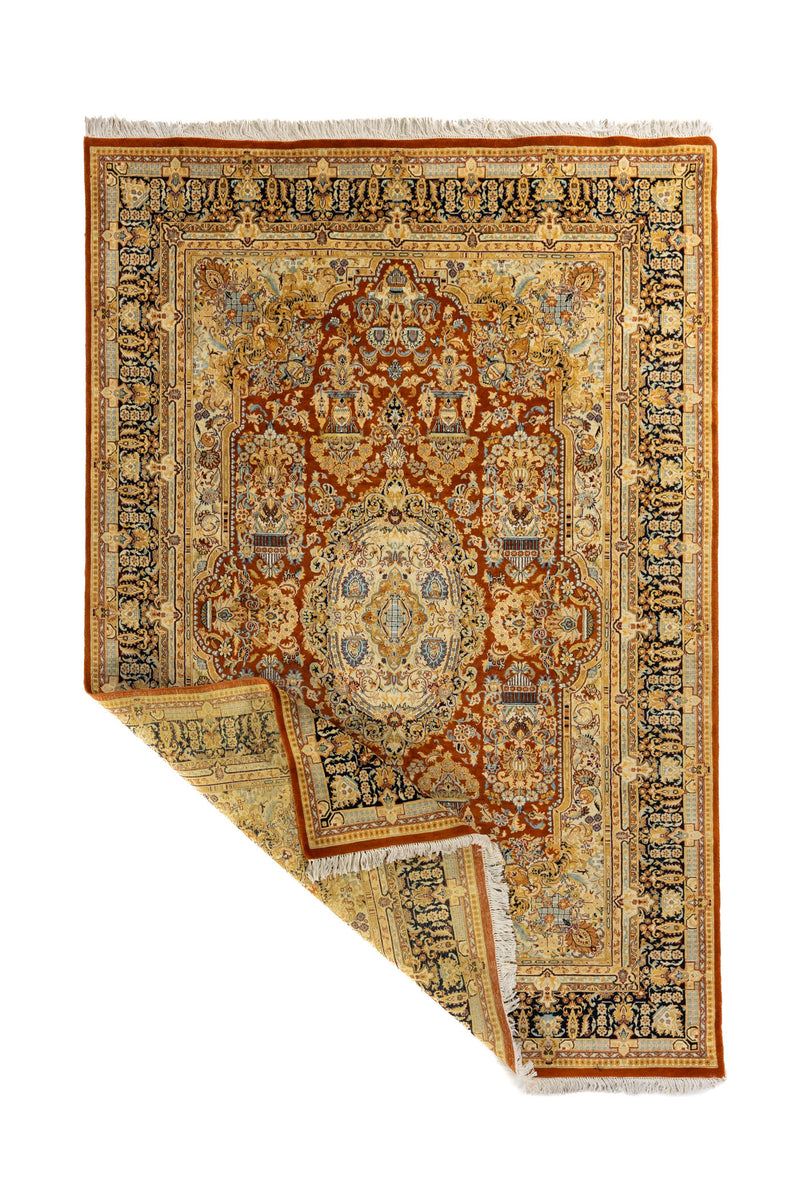 Alfombra clásica persa con esquina levantada mostrando el reverso del tejido y los flecos, destacando su elaboración artesanal.