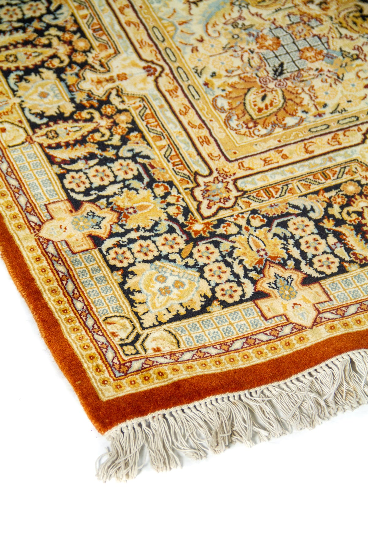 Primer plano del diseño floral de la alfombra con guarda decorativa y detalles intrincados en tonos cálidos.