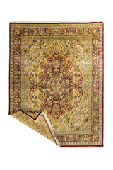 Alfombra persa doblada mostrando el reverso del tejido y los flecos, destacando su confección artesanal y detalles decorativos.