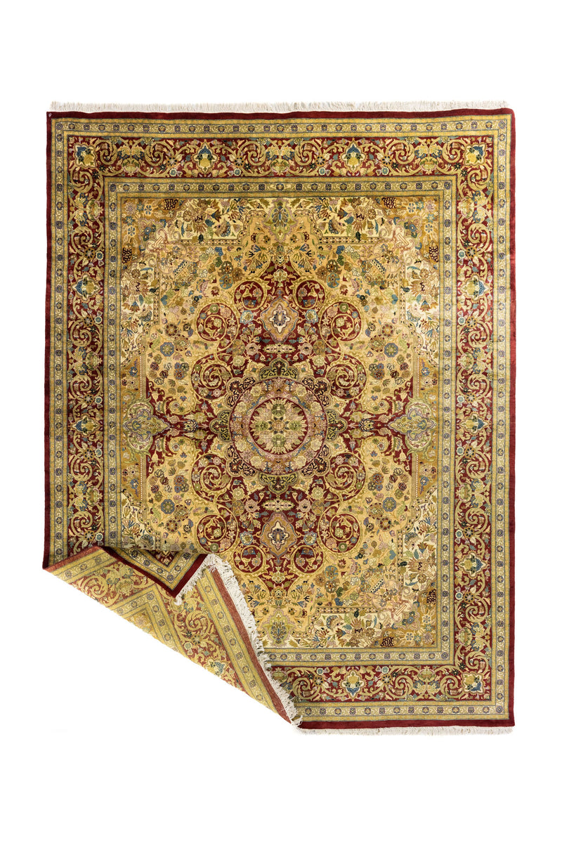 Alfombra persa doblada mostrando el reverso del tejido y los flecos, destacando su confección artesanal y detalles decorativos.