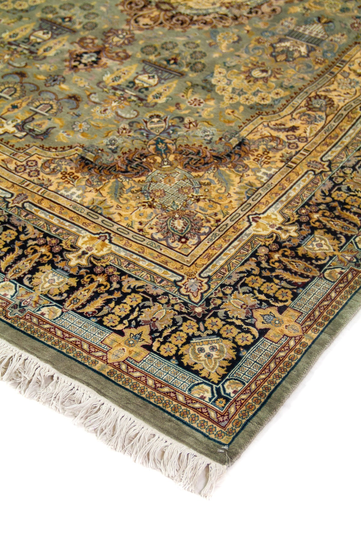 Detalle de esquina de alfombra clásica con borde floral azul oscuro, centro celeste y flecos color beige