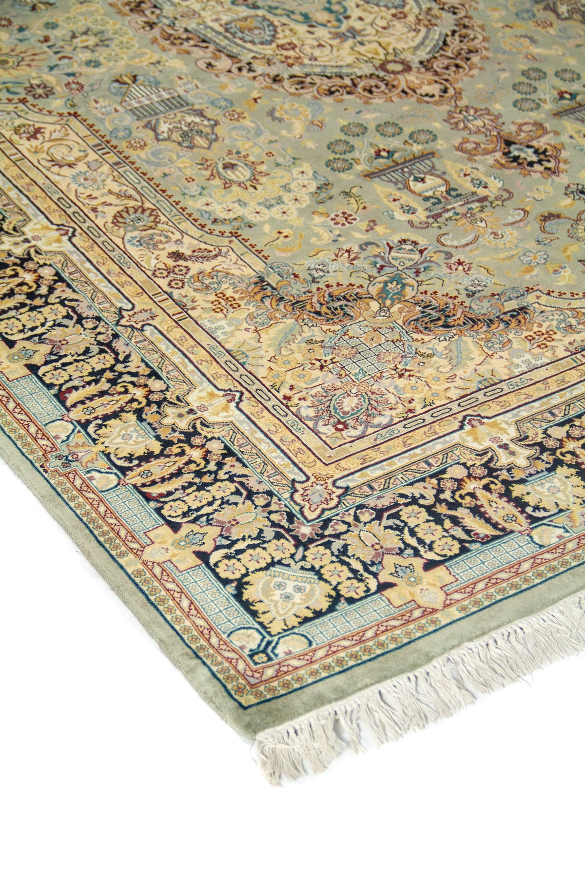 Primer plano de alfombra ornamental con fondo celeste, motivos florales delicados y guarda decorativa en tonos azul y beige