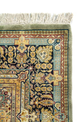 Detalle de borde superior de alfombra con guarda floral oscura, marco decorativo y flecos beige