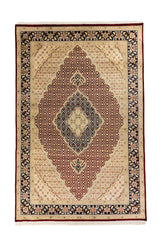 Alfombra clásica de inspiración oriental con fondo beige, gran medallón central en tonos burdeos y azul marino, y guarda floral en azul oscuro y blanco suave .