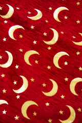 Detalle de textura de tela para almohadón roja con lunas y estrellas doradas