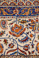 Detalle del diseño floral con arabescos en textil decorativo para pared en tonos beige, azul y rojo