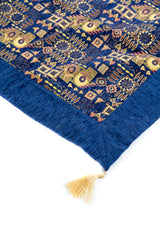Detalle de guarda azul y fleco dorado en textil Kaisery Azul con diseño geométrico