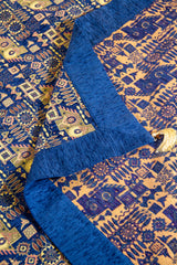 Detalle del reverso y frente del textil Kaisery Azul con motivos geométricos en tonos dorados